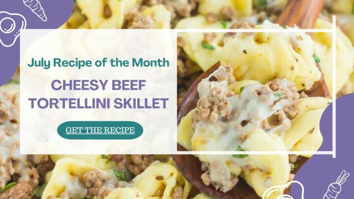 A close-up of cheesy beef tortellini skillet, with melted cheese and ground beef, being served with a wooden spoon. Text overlay reads: Cheesy Beef Tortellini Skillet—July Recipe of the Month. Get the Recipe.