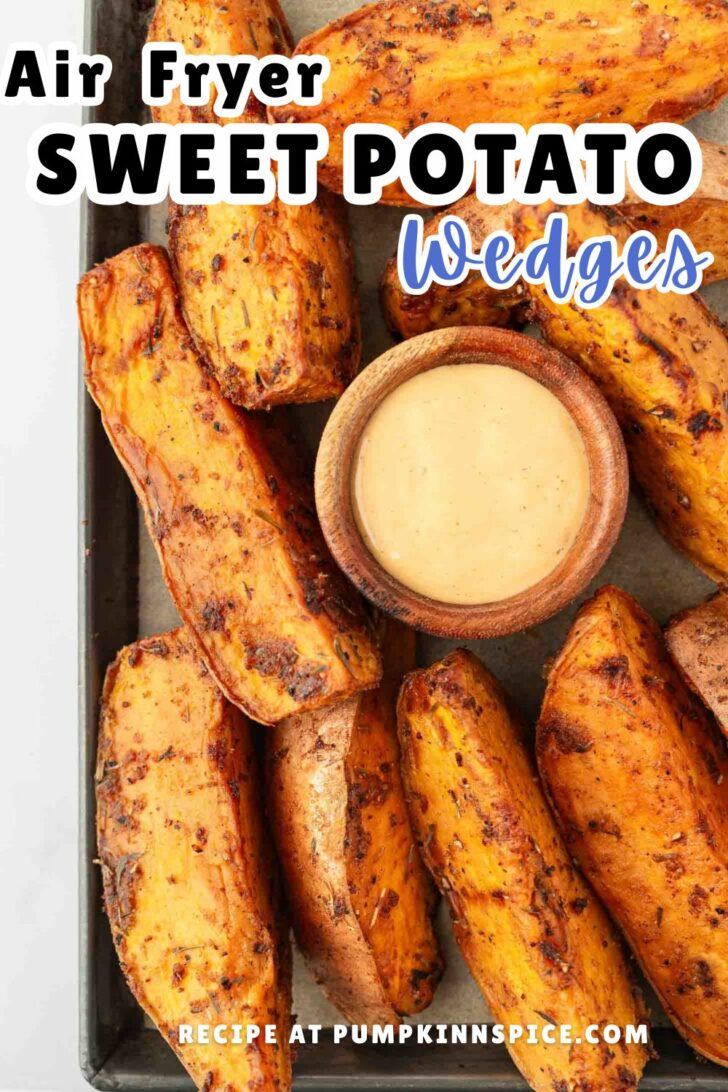 A tray of seasoned sweet potato wedges cooked in an air fryer, arranged around a small wooden bowl of dipping sauce. The text reads: Air Fryer Sweet Potato Wedges. Recipe at pumpkininspire.com.