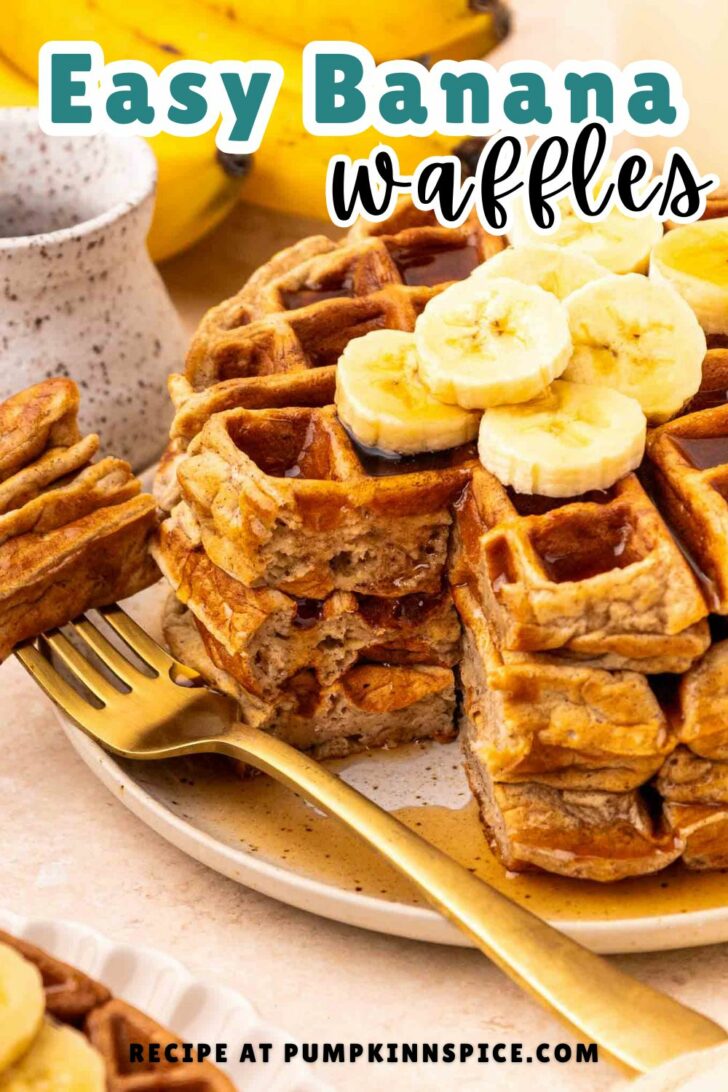 A plate of golden banana waffles topped with banana slices, served with a gold fork. Bananas and a mug are in the background. Text on the image reads: “Easy Banana Waffles. Recipe at pumpkinnspice.com.”.