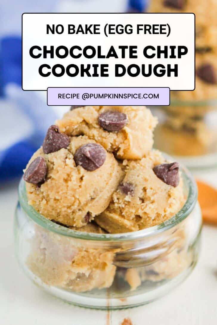 A small glass jar filled with scoops of chocolate chip cookie dough, topped with chocolate chips. Text overlay reads “No Bake (Egg Free) Chocolate Chip Cookie Dough. Recipe @pumpkinnspice.com.”.