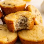 A close-up of mcgriddle muffins on a plate, with one muffin on top showing a bite taken out, revealing its moist, fluffy interior.