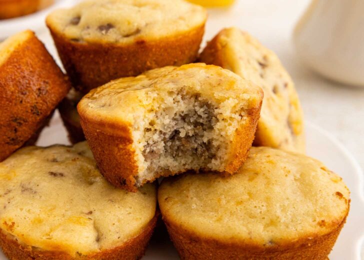 A close-up of mcgriddle muffins on a plate, with one muffin on top showing a bite taken out, revealing its moist, fluffy interior.